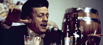 Adoniran Barbosa cantando e bebendo em mesa de boteco