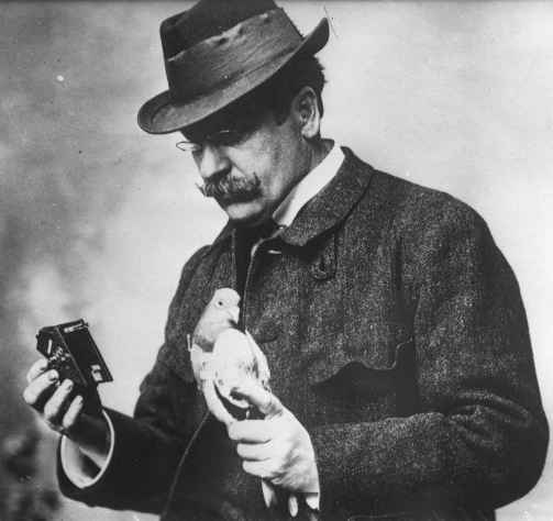 Júlio Neubronner segurando um pombo e uma câmera fotográfica