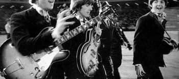 os beatles caminhando com seus instrumentos musicais