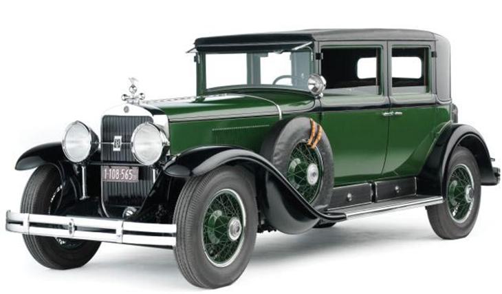 O principal veículo de Capone, um Cadillac v8, modelo 1928. “O Cadillac teria mais de mil quilogramas de blindagem sob o chassi tradicional, janelas à prova de balas de 3 centímetro de grossura, uma sirene e uma luz vermelha piscante. Pintado da mesma cor que as viaturas policiais de Chicago, acredita-se ter sido também o primeiro carro particular com receptor da radiofrequência da polícia”. (CAWTHORNE, 2012, p.71) Créditos: Theo Civitello / RM / BNPS. carro verde e preto de al capone
