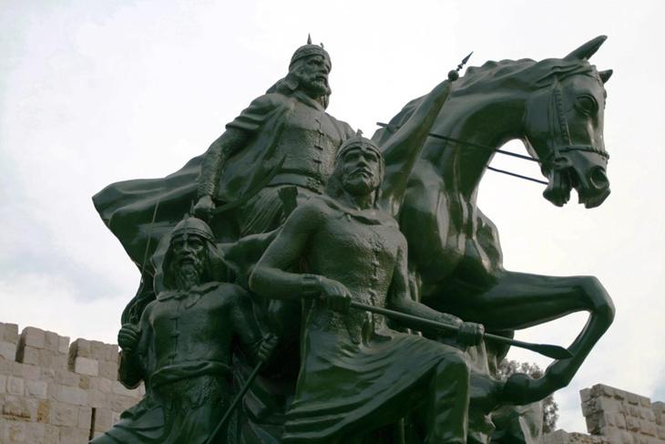 estátua de saladino com soldados e cavalos