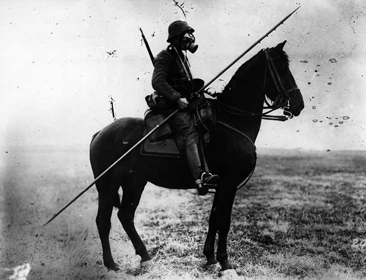 Cavaleiro alemão armado com lança e rifle e protegido por máscara de gás