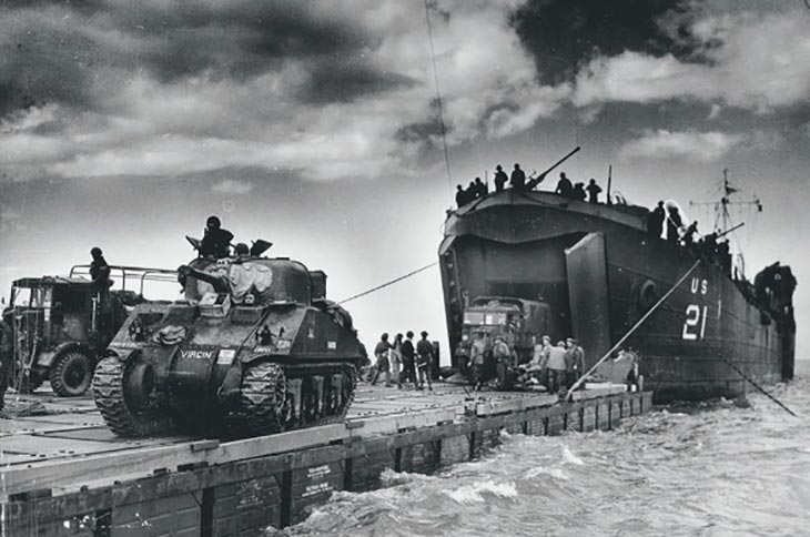 tropas aliadas desembarcando com tanques e caminhões na Normandia no dia D